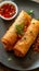 Golden fried spring roll served with a side of sauce