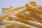 Golden fries on white background. Yellow french fries with wooden sauce cup on plain floor