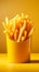 Golden fries in a yellow fast food box, isolated