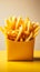 Golden fries in a yellow fast food box, isolated