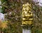 Golden Ganesha sculpture on a stone pole, spiritual decorations for the garden, Elephant god from India