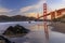 Golden Gate Bridge view from the hidden and secluded rocky Marshall's Beach at sunset in San Francisco, California