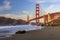 Golden Gate Bridge view from the hidden and secluded rocky Marshall's Beach at sunset in San Francisco, California