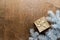 a golden gift box on a wooden table with gold spangles in the shape of stars, among the fir branches