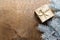 a golden gift box on a wooden table with gold spangles in the shape of stars, among the fir branches