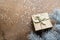 a golden gift box on a wooden table with gold spangles in the shape of stars, among the fir branches