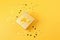 a golden gift box with yellow ribbons on a yellow background. It is an ideal image to illustrate celebration topics, Generative AI