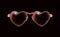 Golden glasses with a rim of hearts, isolated in black background. Eyeglasses obligatory Attribute of Valentines day. Retro design
