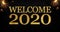 Golden glitter with the words welcome 2020 on black chalkboard background