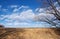 Golden Grassy Slope and Sky with Clouds in Winter