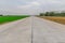 Golden and green colors of rice fields on the opposite of the concrete road.