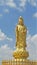 Golden Guanyin statue on a clear sky background