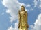 Golden Guanyin statue on a clear sky background