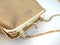 Golden handbag over white background