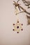 Golden hanging ornament with purple gems on a wooden branch as Christmas decoration. Natural wood and intricate shiny ornament