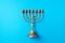 Golden hanukkah menorah on blue background. Jewish holiday banner with copy space. Ancient ritual religious candle