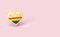 Golden heart pin with rainbow and word PRIDE inside. Month of pride concept. Isolated on pastel pink background with copy space.