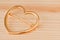 Golden heart shaped hair clip closeup shot on a wooden surface