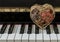 Golden heart shaped mesh case is filled with dried fruits stand on the Piano Keyboard