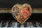 Golden heart shaped mesh case is filled with dried fruits stand on the Piano Keyboard