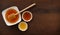 Golden Honey in a White Bowl with Dipper on Wooden Table, Copy Space