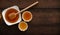 Golden Honey in a White Bowl with Dipper on Wooden Table, Copy Space