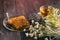 Golden honeycomb with honey and tea linden flowers on wooden background