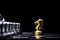 Golden horse chess encounters with silver chess enemy on chess board and black background. Market or business competitor concept