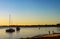 Golden hour with fishermen and boats moored in the harbor and a low flying bird on Bribie Island Australia