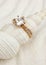 Golden jewelry ring on white seashell, macro