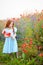 Golden kid girl gathers a bouquet of wild flowers for mother