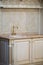 Golden kitchen faucet. Neoclassical style white and gold wooden kitchen in luxury home