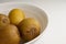 Golden Kiwifruit or Chinese gooseberry Actinidia chinensis in a bowl, on white background