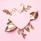 Golden leaves, heart shaped paper on pink background with copy space. Top view. Copy space. Summer and autumn concept. Creative