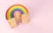 Golden LGBTQ rainbow pile for gay pride, LGBT, bisexual, homosexual symbol concept. Isolated on pastel pink background with copy