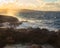 Golden light hitting water spraying over rocks