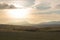 Golden light over fields and mountains