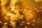 Golden lights in the shape of hearts in the defocus on a dark background. Celebrating Valentine`s Day,gold blurred background with