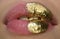 Golden lipstick closeup. Lips with metal makeup. Sexy lips, Metallic lipstick close up. Golden art design.