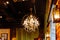 Golden luxury chandelier or luster with crystal pendants and round metal decor or lampshade. Front view