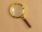 Golden magnifying lens over craft carton. Search tool