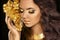 Golden makeup eyes closeup. Beautiful young woman in gold with f