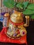 Golden Maneki-neko in oriental style decoration. Close up of lucky cat in business. Fortune cat waving with both paws to protect