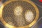 The golden mantra in the circle is painted on black paper and is
