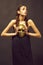 Golden mask in hand of mysterious beautiful woman, glamour