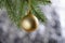 Golden matte Christmas ball hangs on a spruce branch