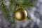 Golden matte Christmas ball on a spruce branch