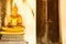 Golden meditating buddha next to close door at Wat Phutthaisawan