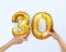 Golden metal balloon number thirty 30. party decoration with Golden balloons. The number 30 is in your hand.Anniversary sign for a