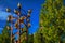 Golden metal birds monument with leafy tree and steeple in sunny day at Weesp.